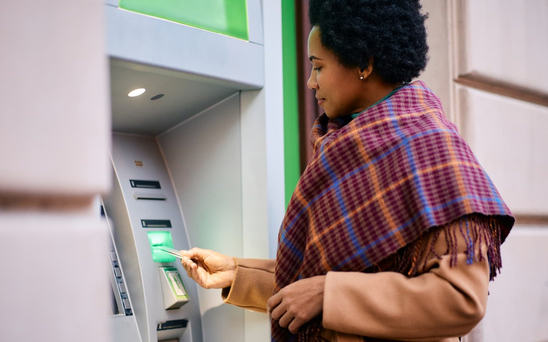 African american woman withdrawing money from atm.